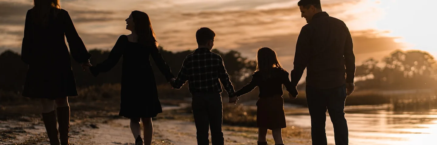 Family walking together on a tropical beach at sunset in Indonesia
